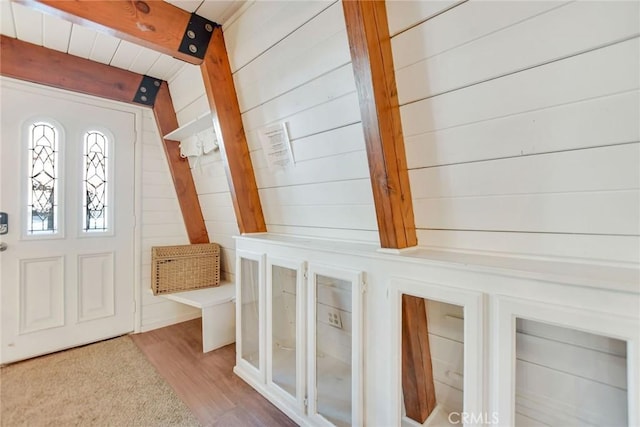 mudroom featuring light wood-type flooring, beamed ceiling, and wooden walls