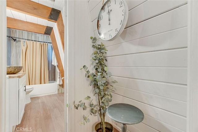 full bathroom with wood walls, hardwood / wood-style flooring, beamed ceiling, and vanity