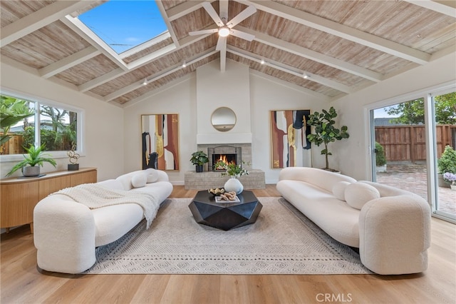 living room featuring hardwood / wood-style floors, a skylight, a fireplace, and wooden ceiling