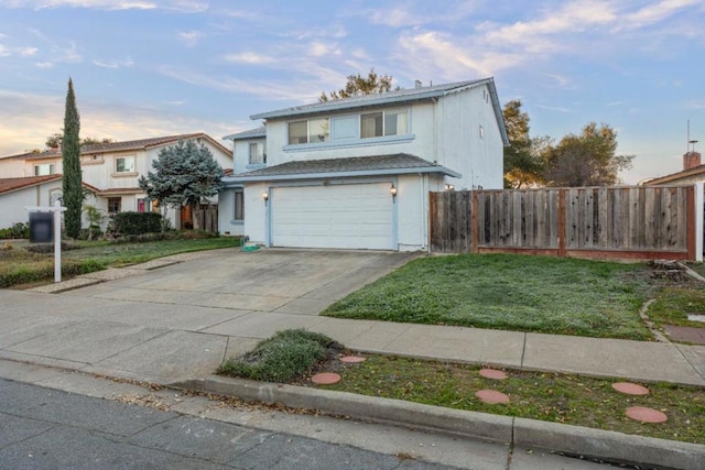 view of property featuring a garage and a lawn