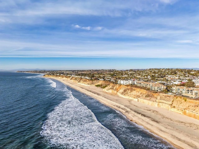 drone / aerial view featuring a water view and a view of the beach