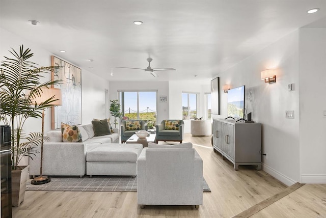 living room with light wood-type flooring and ceiling fan