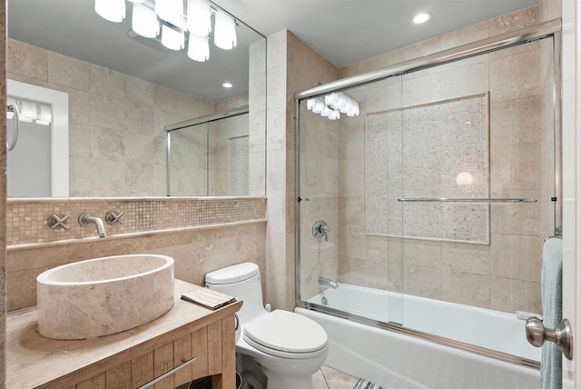 full bathroom featuring enclosed tub / shower combo, tile patterned flooring, vanity, tile walls, and toilet