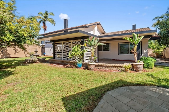 rear view of house with a patio area and a yard