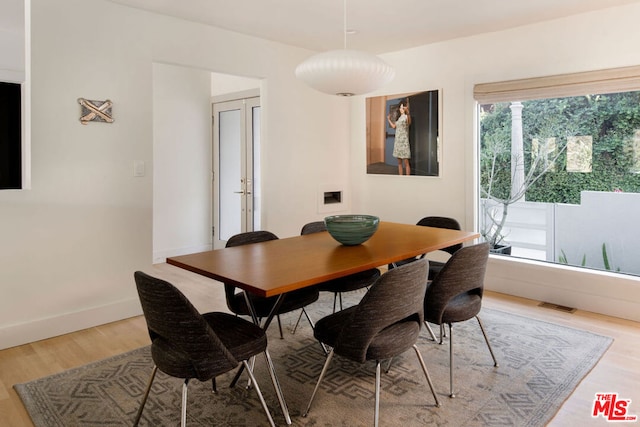 dining area with hardwood / wood-style floors and french doors