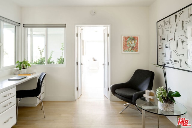 office area with light wood-type flooring and built in desk