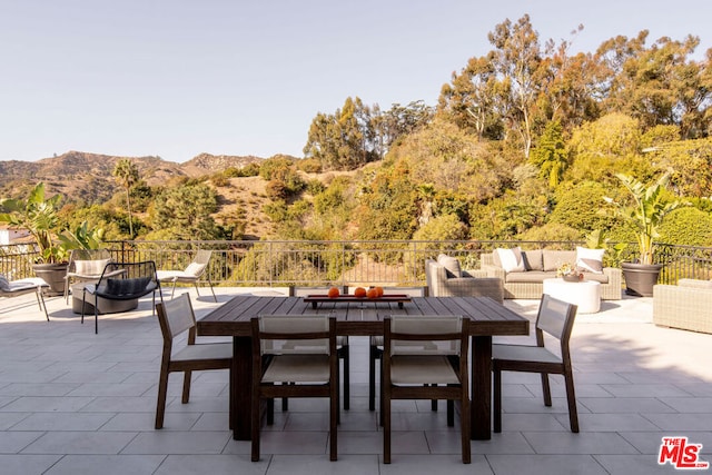 view of patio / terrace featuring a mountain view and an outdoor living space with a fire pit