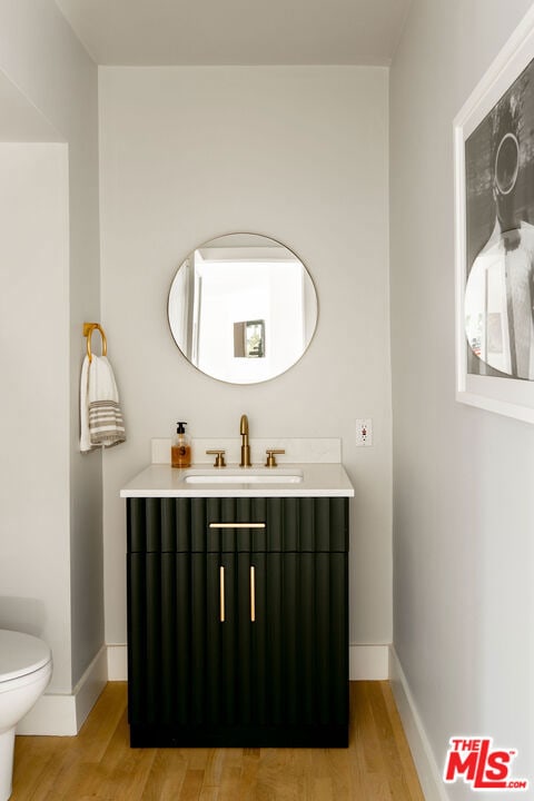 bathroom featuring vanity, toilet, and hardwood / wood-style floors