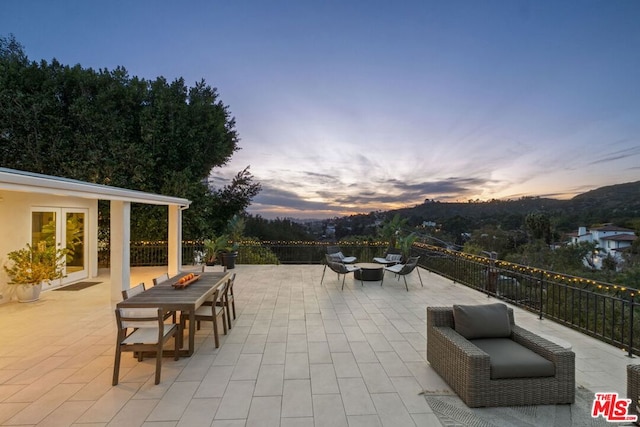 patio terrace at dusk featuring an outdoor fire pit