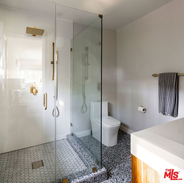 bathroom featuring toilet and a shower with door