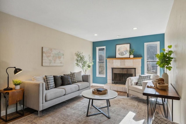 living room with a tile fireplace and hardwood / wood-style floors