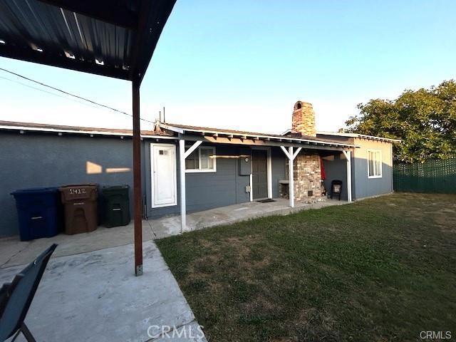 rear view of house with a patio area and a lawn