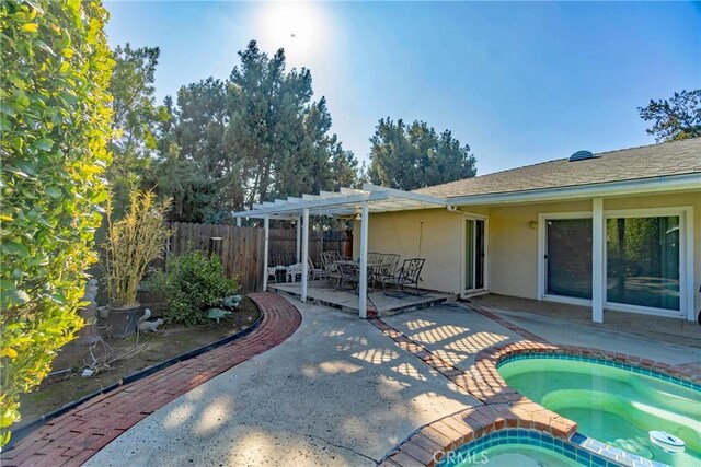 exterior space with a patio, an in ground hot tub, and a pergola