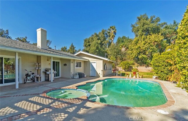 view of pool with an in ground hot tub, a patio, central AC, and a grill