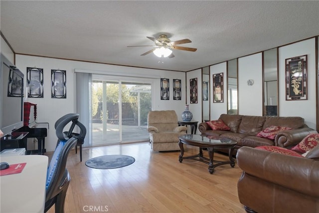 living room with a textured ceiling, light hardwood / wood-style flooring, and ceiling fan