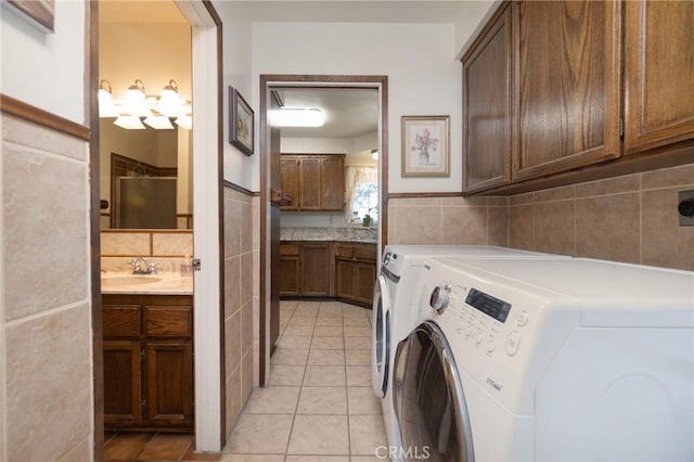 washroom with cabinets, light tile patterned floors, sink, and independent washer and dryer