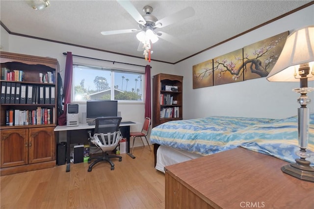 bedroom featuring ceiling fan, light hardwood / wood-style floors, a textured ceiling, and ornamental molding