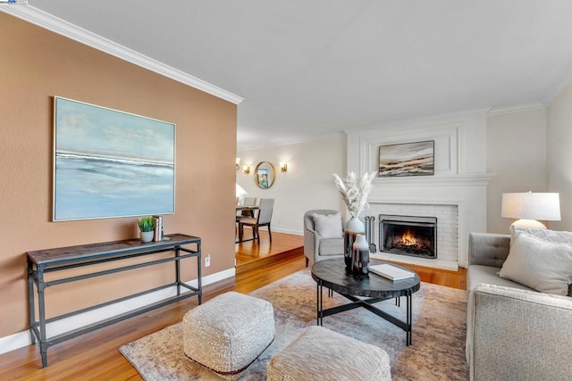 living room featuring hardwood / wood-style flooring, a brick fireplace, and ornamental molding