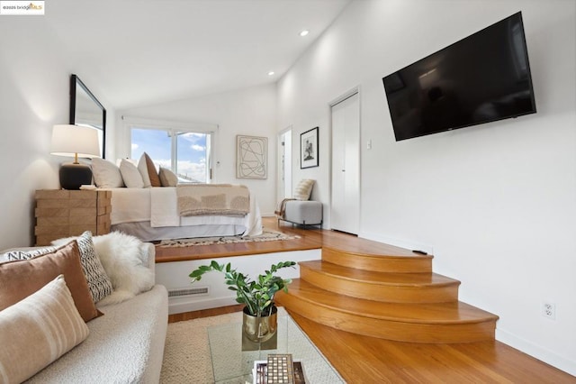 living room with wood-type flooring and high vaulted ceiling