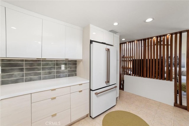 kitchen with white cabinets, decorative backsplash, and high end fridge