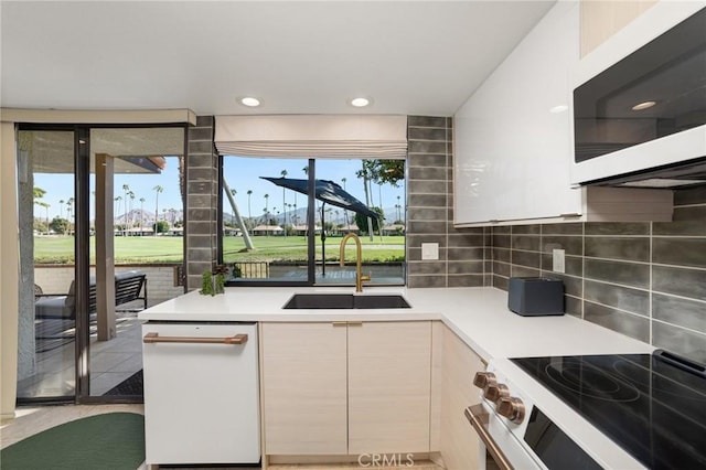 kitchen with sink, a water view, stainless steel range with electric stovetop, and tasteful backsplash