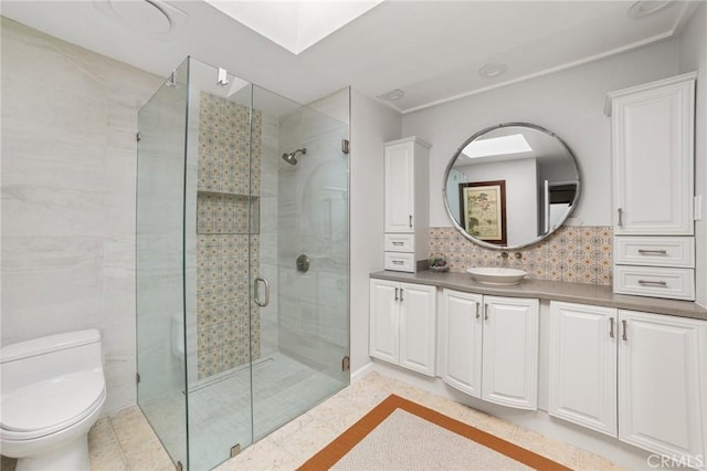 bathroom with tile patterned floors, vanity, decorative backsplash, toilet, and a shower with shower door