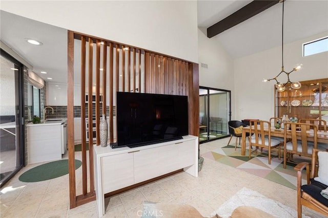 living room featuring beamed ceiling, light tile patterned floors, sink, high vaulted ceiling, and an inviting chandelier