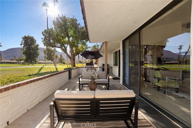 view of patio with a mountain view, outdoor lounge area, and a balcony