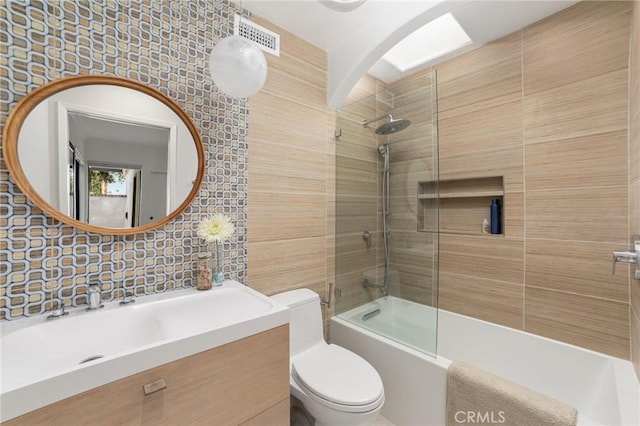 full bathroom featuring decorative backsplash, toilet, vanity, and tiled shower / bath