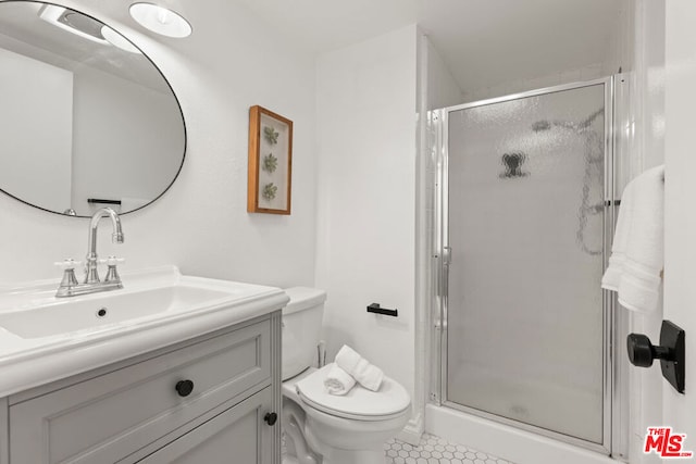 bathroom with a shower with door, toilet, tile patterned floors, and vanity