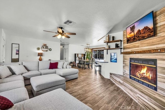 living room featuring ceiling fan and a textured ceiling