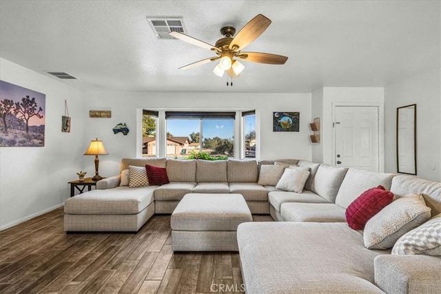 living area with baseboards, ceiling fan, visible vents, and dark wood-style flooring