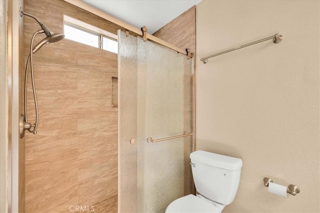 full bathroom featuring a stall shower and toilet