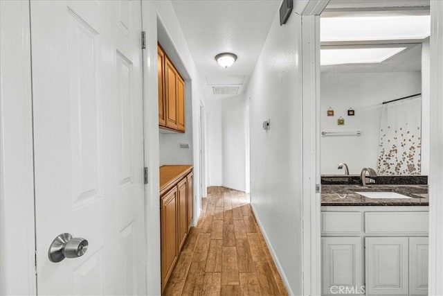 corridor with sink and hardwood / wood-style flooring