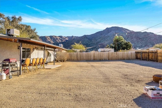 view of yard featuring a mountain view, a patio, and central AC