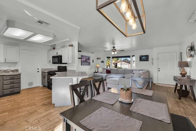 dining room featuring ceiling fan, light wood-type flooring, and visible vents