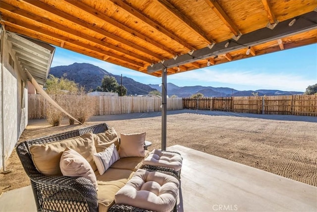 view of patio / terrace featuring an outdoor living space, a fenced backyard, and a mountain view