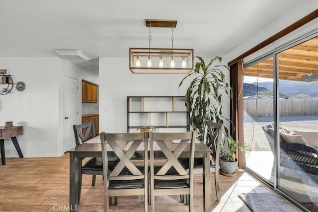 dining space with light wood finished floors, visible vents, and baseboards