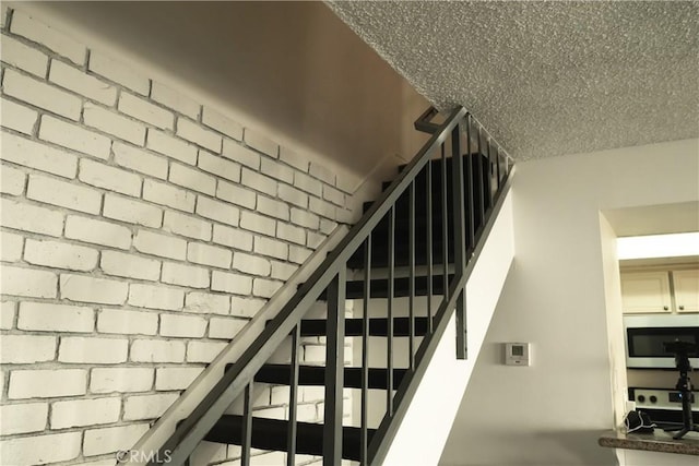 stairs with a textured ceiling