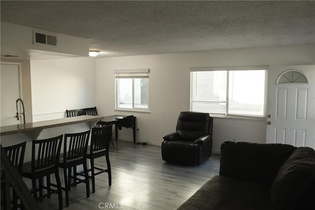 dining room featuring sink, light hardwood / wood-style flooring, and a textured ceiling