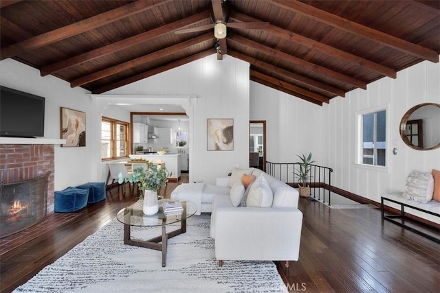 living room with wood ceiling, dark hardwood / wood-style floors, lofted ceiling with beams, and a brick fireplace