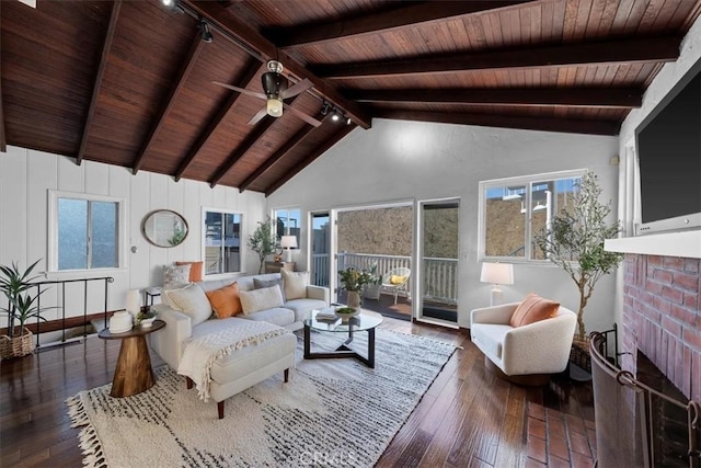 living room featuring beamed ceiling, a fireplace, dark hardwood / wood-style flooring, and wooden ceiling