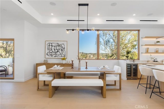 dining area featuring wine cooler, light hardwood / wood-style flooring, and breakfast area