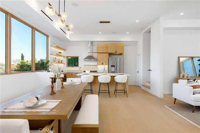 dining area featuring a chandelier, sink, and light wood-type flooring