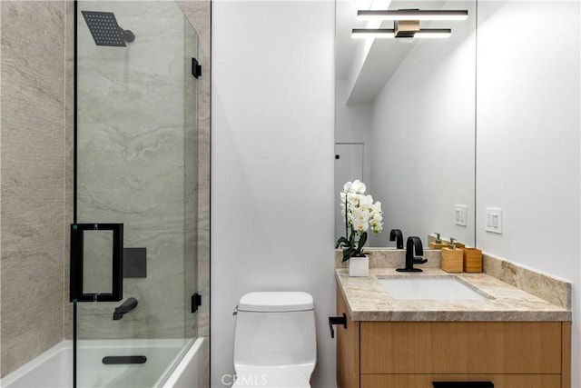 full bathroom featuring vanity, toilet, and combined bath / shower with glass door