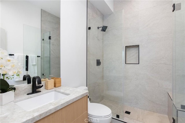 bathroom with vanity, an enclosed shower, and toilet