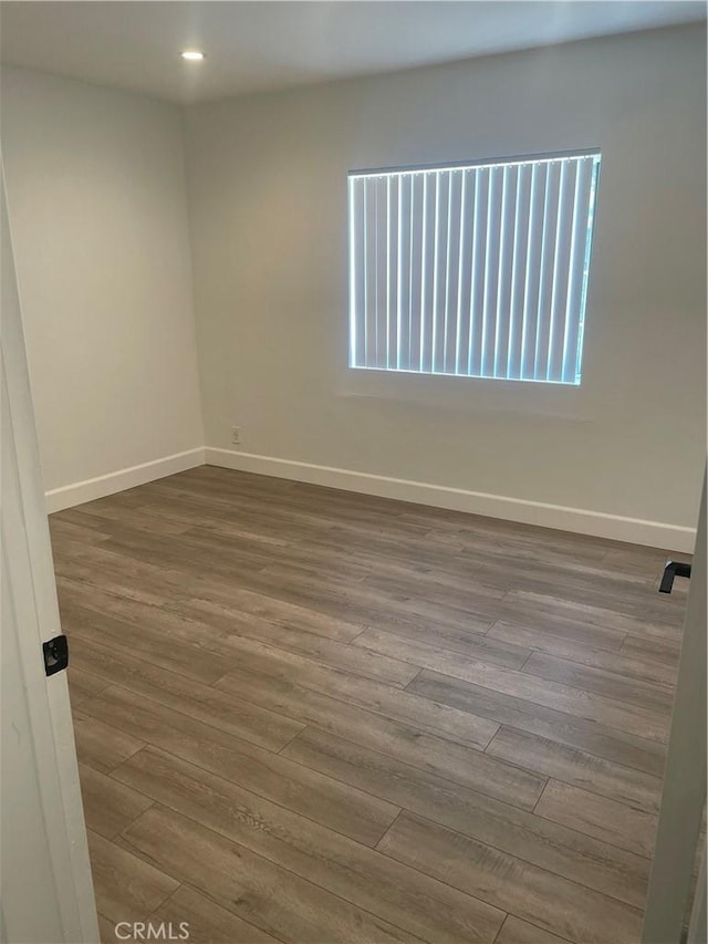 spare room featuring hardwood / wood-style flooring and a wealth of natural light