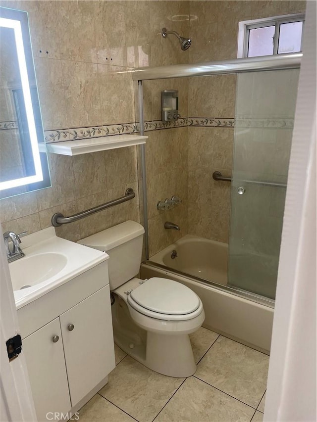 full bathroom featuring toilet, vanity, shower / bath combination with glass door, and tile patterned flooring