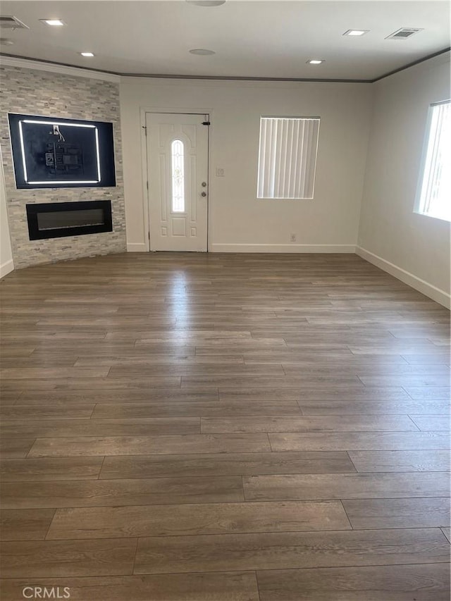 entryway featuring wood-type flooring, a large fireplace, and plenty of natural light