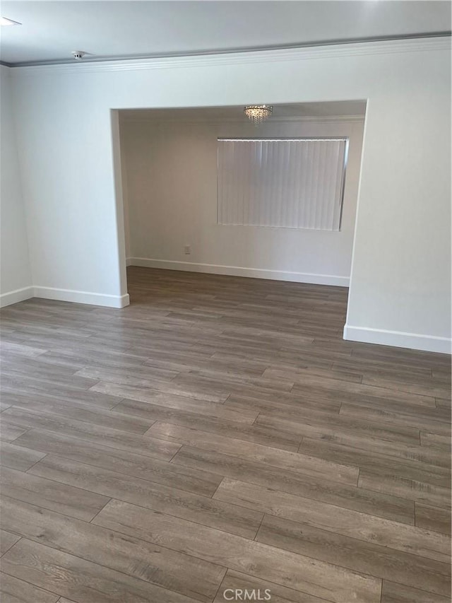 spare room featuring crown molding and wood-type flooring